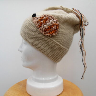 hand knit Hedgehog hat on a porcelain head